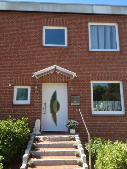 Kunststoff-Haustür in weiß mit zwei abgerundeten Lichtausschnitten bei Einfamilienhaus