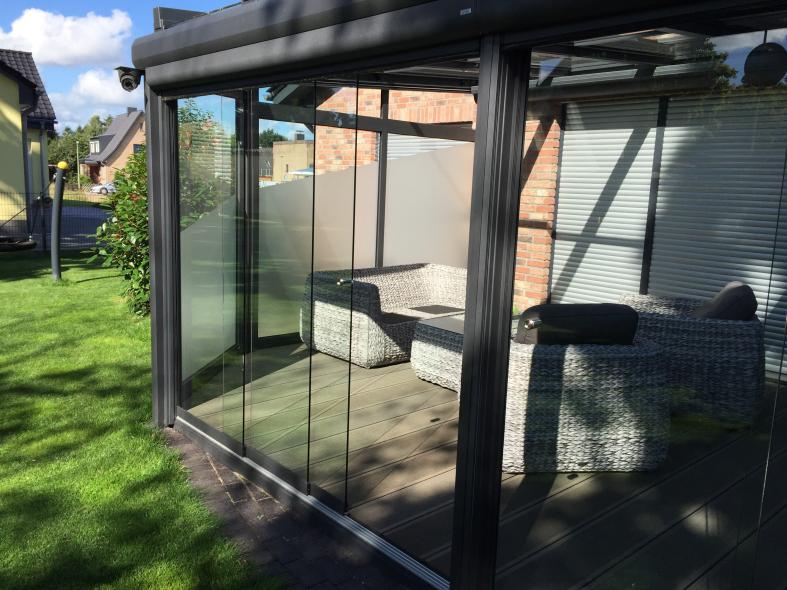Wintergarten in anthrazit mit Glasdach und Glas-Schiebetüren mit Milchglas-Sichtschutz
